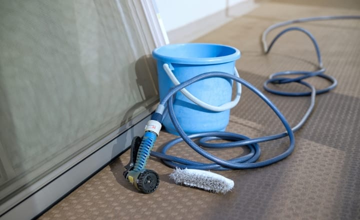 写真:外された網戸の横にホースやバケツ、ブラシが置かれている